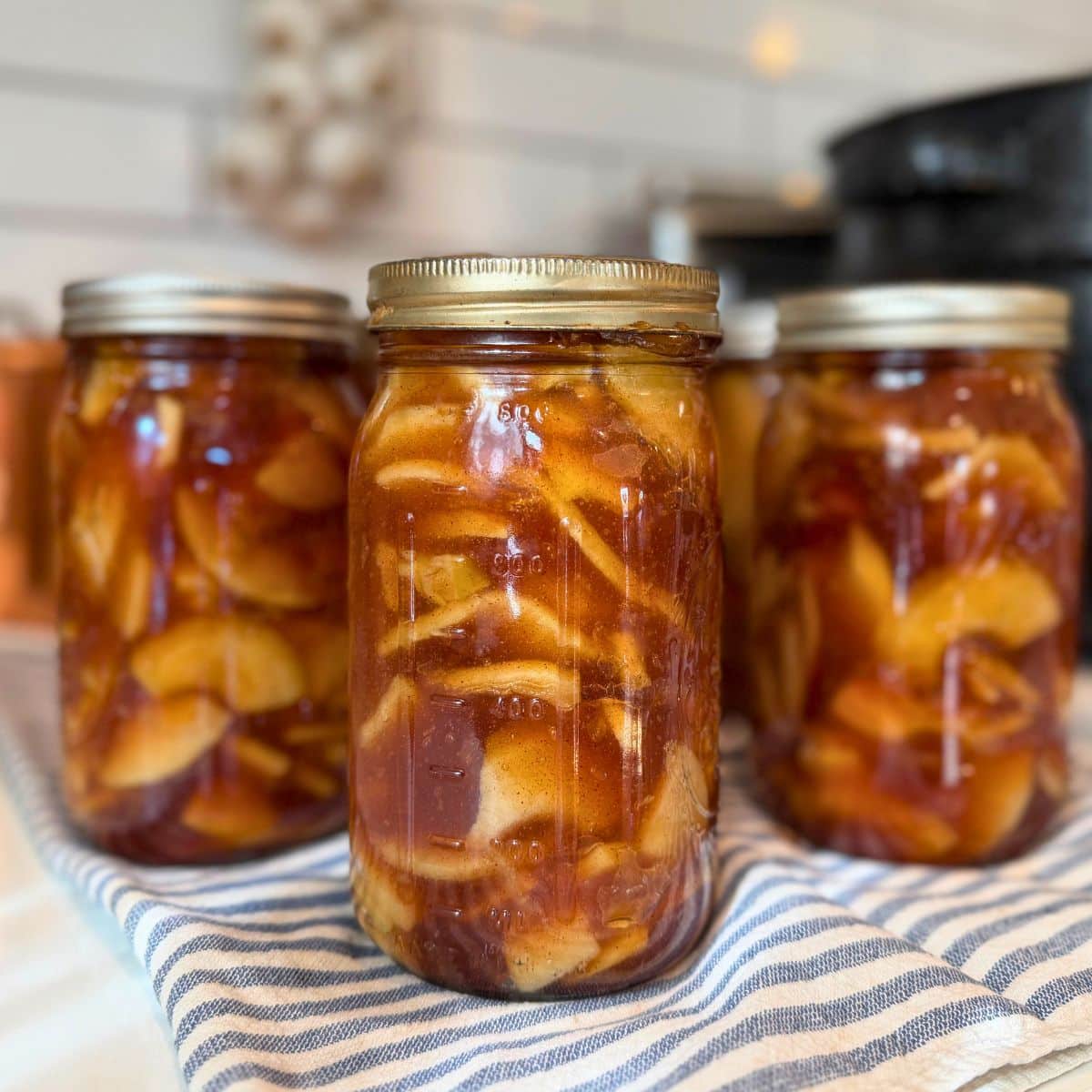 Apple Pie Filling canned in quart jars with water bath canner in background