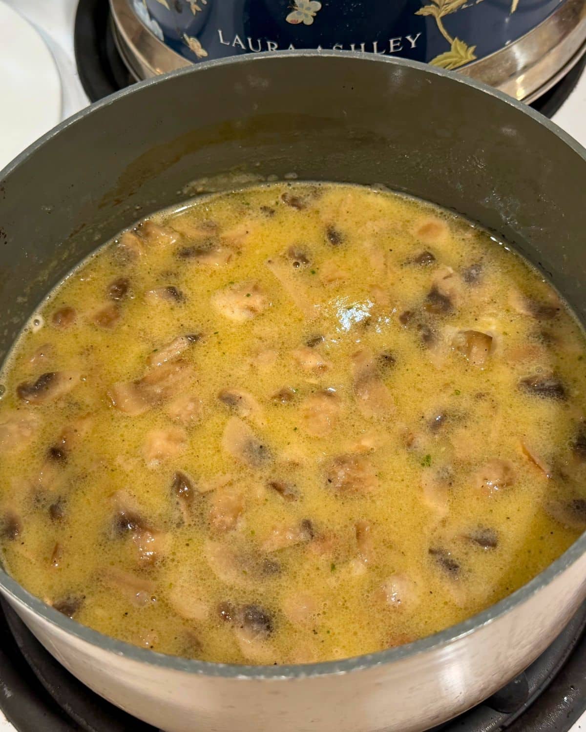 flour whisked into butter and mushroom mixture in saucepan on stove top