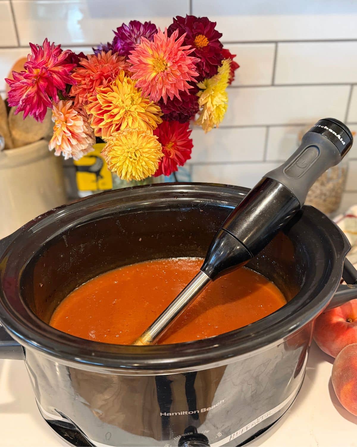 immersion blender in slow cooker with peach butter