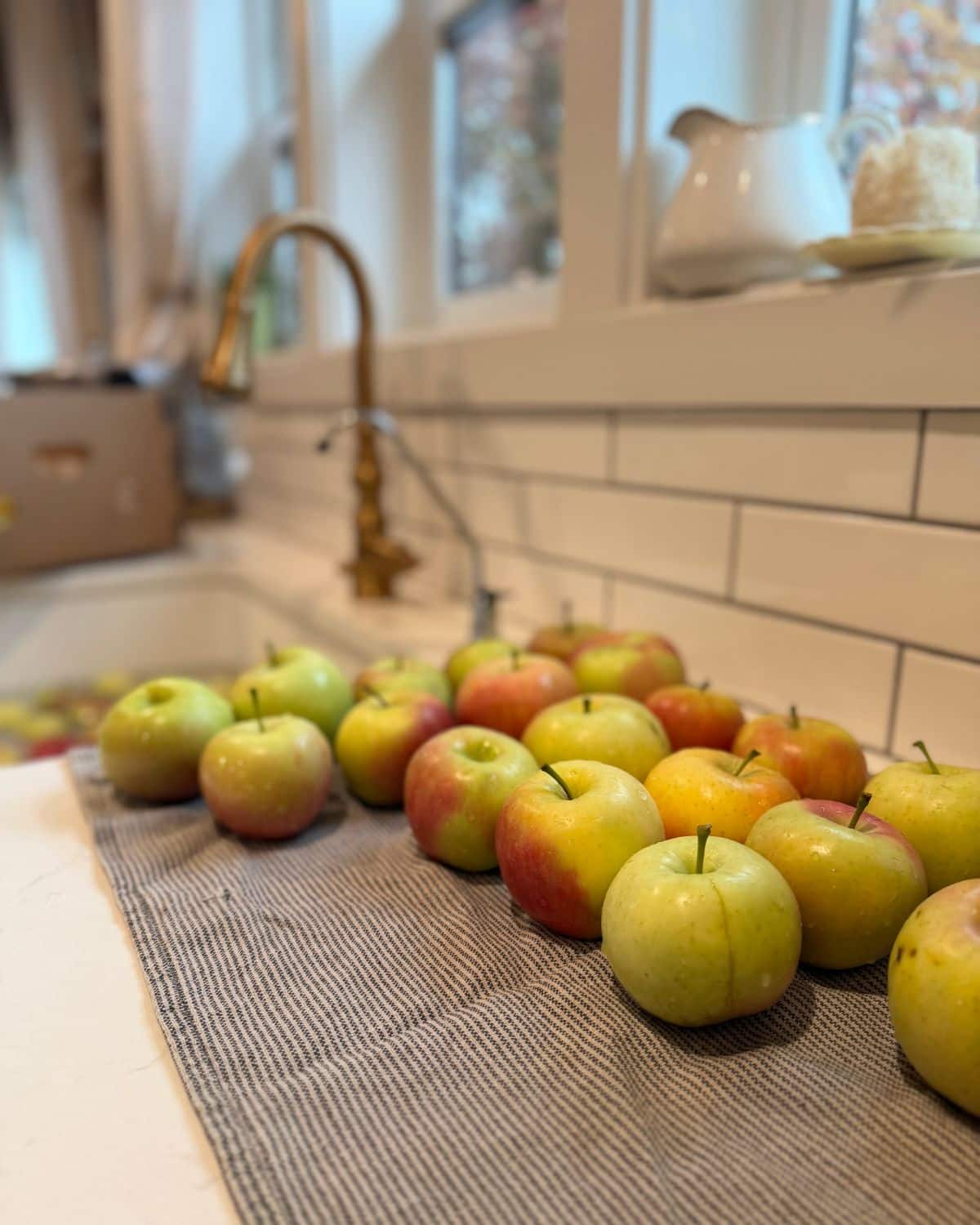 washing apples in the kitchen sink and letting the mdry on a kitchen towel on the counter