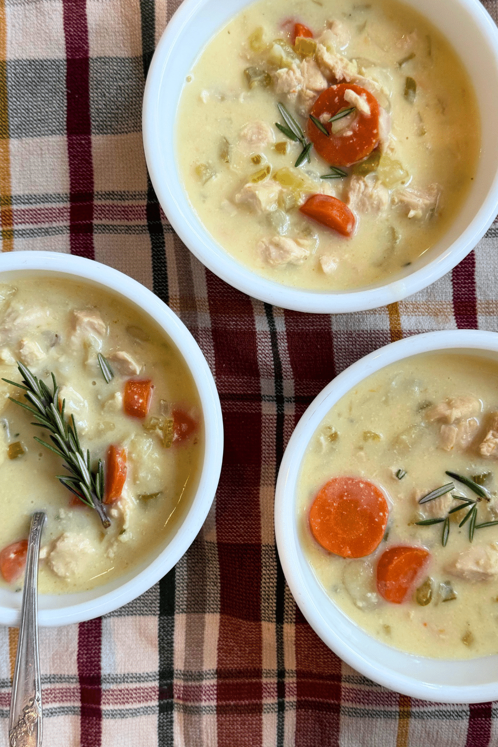 creamy chicken gnocci soup served in white bowls garnished with fresh herbs