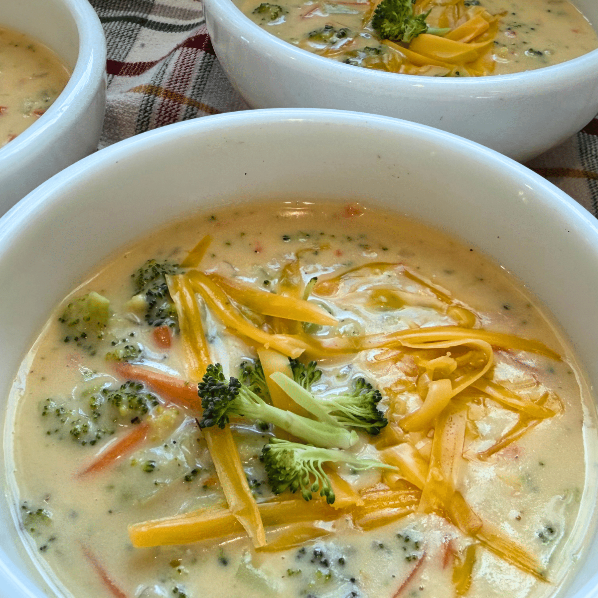 broccoli cheddar soup recipe garnished and served in white bowls
